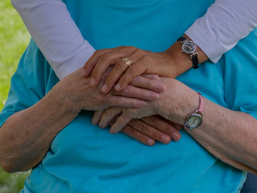 Caregiver holding hands with a loved one, representing special needs trust planning