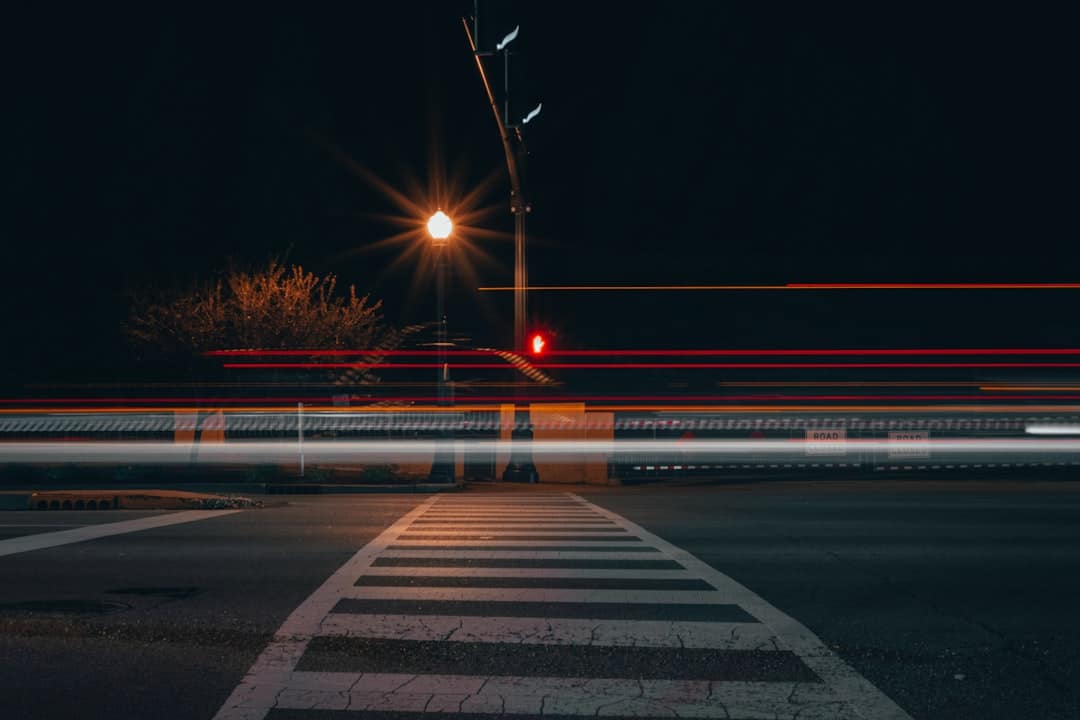 Car light streaks on a road at night, representing nighttime driving risks
