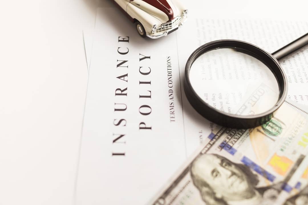 Motor insurance policy documents with a toy car, representing Florida no-fault PIP insurance