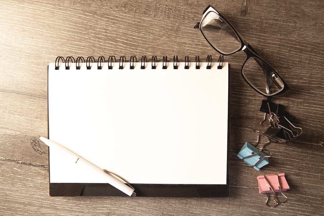 Notebook, pen, and glasses on a desk, representing wills and trusts document planning