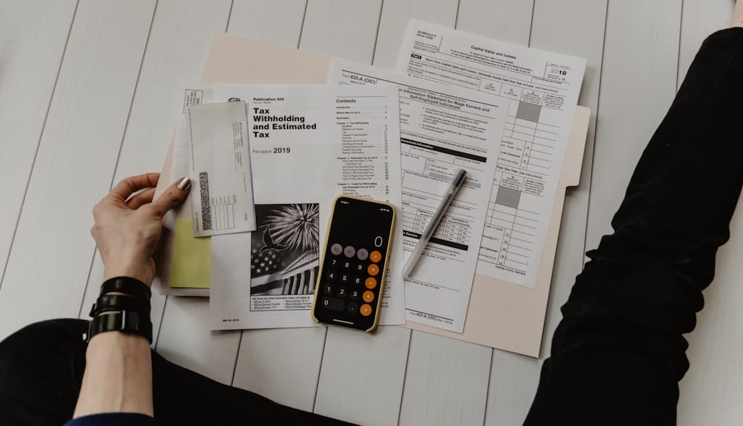 A person reviewing financial paperwork with a calculator