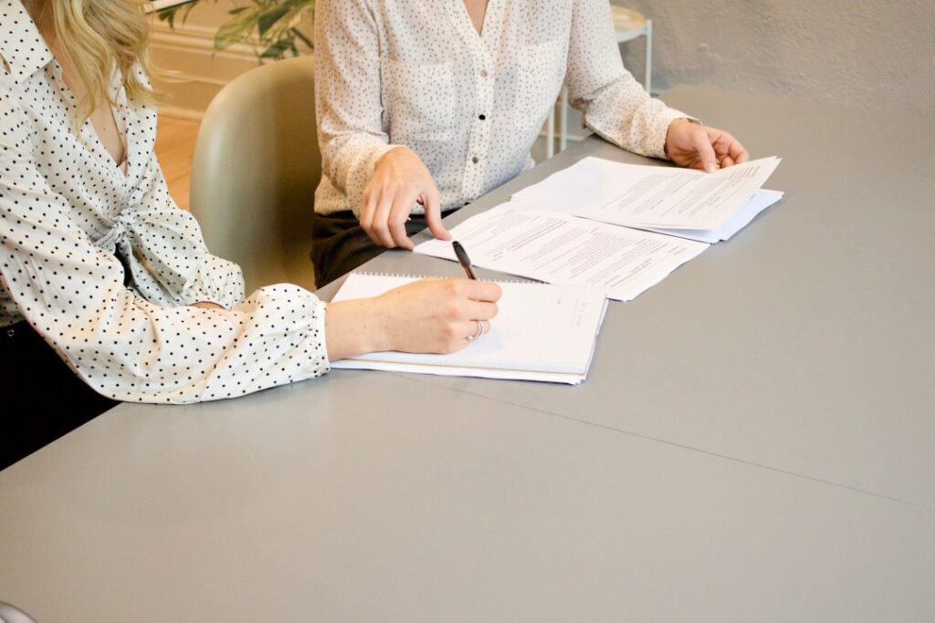 A person signing legal documents at a desk