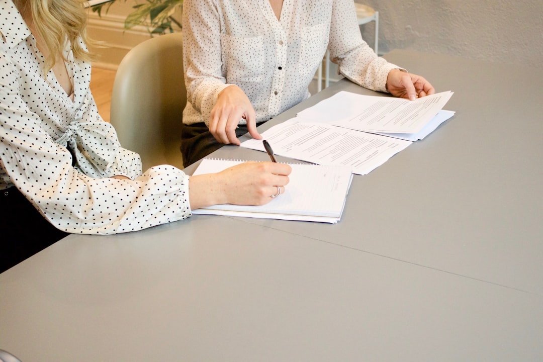 A person signing legal documents at a desk