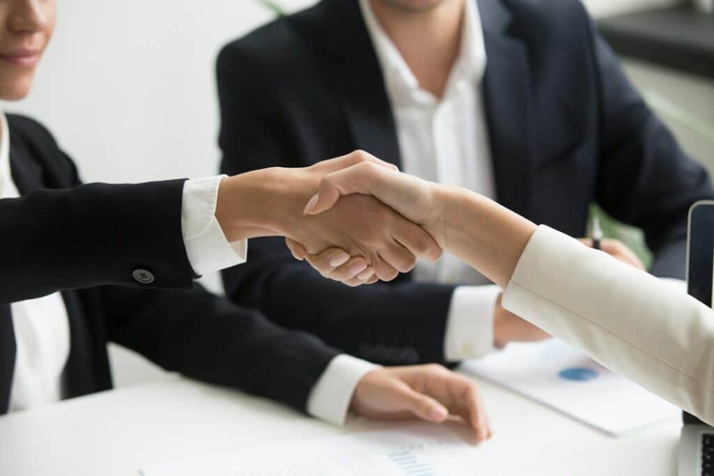 An attorney and client shaking hands across a desk